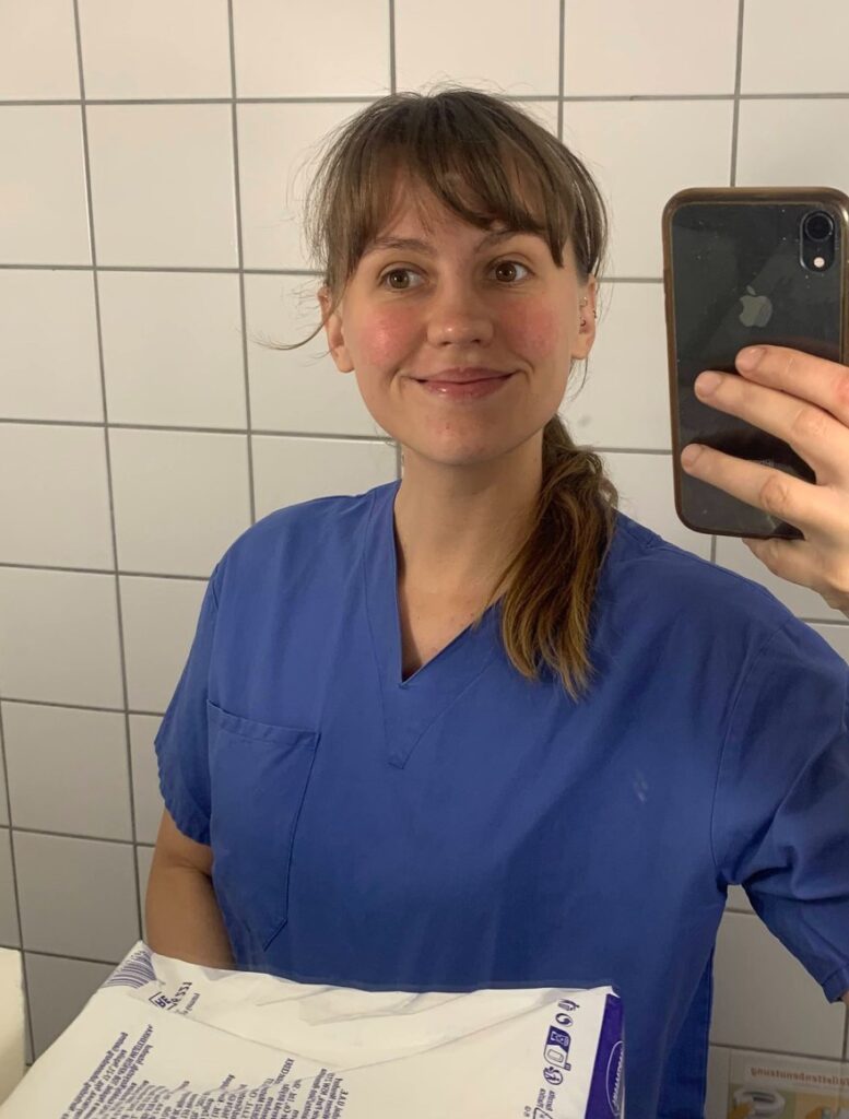Jara im blauen Kasack beim Kreißsaalpraktikum, Selfie im Spiegel